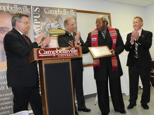 CU-Louisville graduate, the Rev. Matthew Smyzer, was awarded the first Kente Cloth as he and other degree recipients were honored June 11 at Campbellsville University’s Louisville Center. Smyzer, who earned his master of theology degree, is a member of the CU Board of Trustees, pastor of Beargrass Missionary Baptist Church and executive director of Baptist Fellowship in Louisville. With him at the celebration were his wife Joann and daughter Felicia. (Campbellsville University Photo by Linda Waggener)
