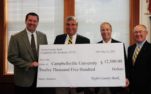 Taylor County Bank CEO Henry Lee, second from left, donates a check for $12,500 for the Campbellsville University School of Education and for an athletic Corporate Scholarship. With him for the presentation were, from left: Benji Kelly, vice president for development; Dr. Michael V. Carter, president; and Chuck Vaughn, director of the Big Maroon Club. (Campbellsville University Photo by Joan C. McKinney)