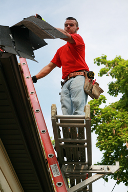 CU student, Collin Johnson of Shelbyville, Ky., removes old shingles from the roof during training week for KHO summer camp. (KHO Photo by André Tomaz) 