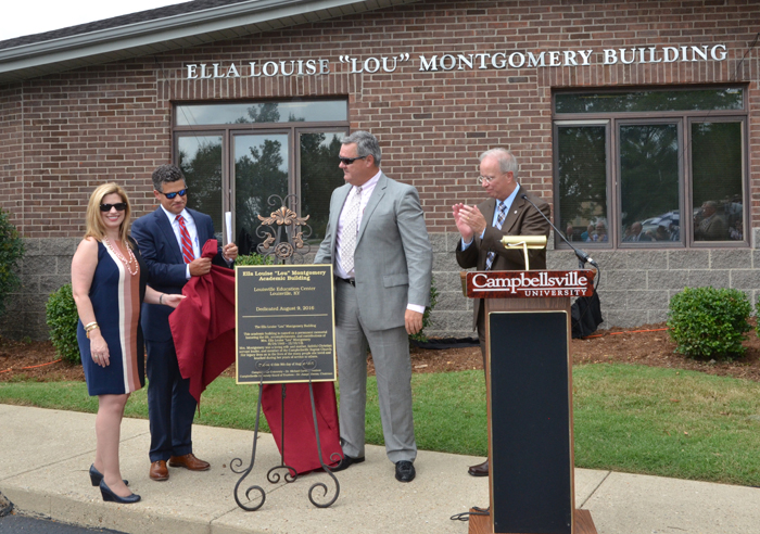 Dr. Michael V. Carter, president of Campbellsville University, applauds during the unveiling of the plaque naming of the Ella Louise “Lou” Montgomery academic building at the Louisville Education Center. From left are Stephanie Montgomery, Kris Mullins and Alex Montgomery, widower of Lou Montgomery. (Campbellsville University Photo by Joan C. McKinney) 