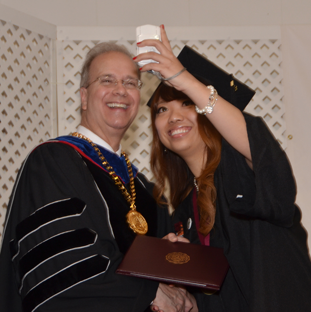 Ye Wei of China, known as Vicky, takes a picture of her and Dr. Michael V. Carter to post on Face- book to send to her family and friends at the undergraduate commencement. (Campbellsville  University Photo by Joan C. McKinney)