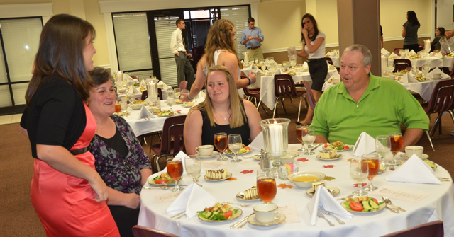 Lauren Goodin, left, an admissions counselor of Columbia talks with Sheila Wilson, left, and her husband, Brian, who were at the Central Kentucky Scholars' Day dinner with their daughter, Emily, center. (Campbellsville University Photo by Joan C. McKinney)