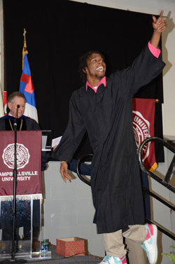 Xavier Scott Wells gives a shout to his family as he walks across stage. Wells, of Central City, Ky., received a bachelor of science in sport management. (Campbellsville University Photo by Naranchuluu Amarsanaa)