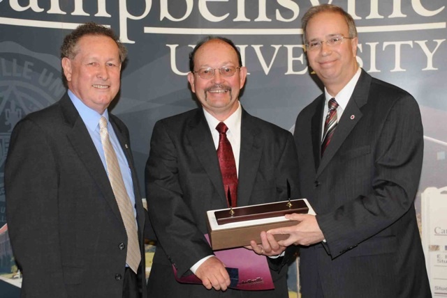 Joe Foster, center, was honored for 25 years of service to Campbellsville University by Dr. Frank Cheatham, left, and Dr. Michael V. Carter, president. (Campbellsville University Photo by Ashley Zsedenyi)