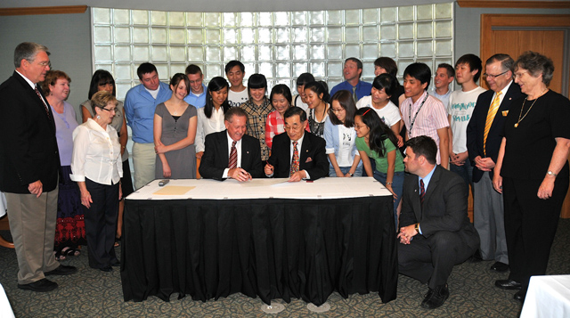  Dr. Frank Cheatham, Campbellsville University vice president for academics, seated center left, and  Dr. James Chin-Kyung Kim, center right, president of Yanbian University of Science and Technology (YUST), and of Pyongyang University of Science and Technology (PUST), met in the Chowning Executive Dining Room of Winters Dining Hall at CU and signed agreements of academic articulation. They were joined by a group of YUST students and CU leaders and students. (Campbellsville University Photo by Linda Waggener)