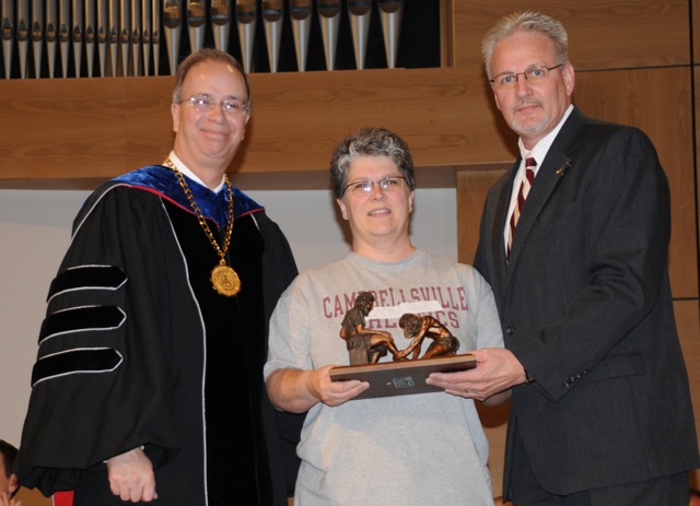 Jo Ann Harris, center, receives the staff Servant Leadership Award from Dr. Michael V. Carter, president of Campbellsville University, and Dave Walters, vice president for admissions and student services, at Honors and Awards Day. (Campbellsville University Photo by Ashley Zsedenyi)