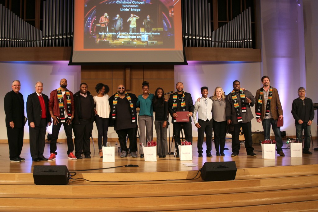 Linkin’ Bridge was honored with the CU Kente Cloth at Campbellsville University after the concert. In the photo from left are:  Dr. Keith Spears, vice president for communications and assistant to the president; Dr. Michael V. Carter, president; Linkin’ Bridge member Ekoe Alexanda; CU students CJ Calhoun and Maya Spalding; Linkin’ Bridge member Montre Davis; CU students Shannon Martin and Natalie Zetrenne; Linkin’ Bridge member Shon China Lacy;  CU student Fontez Hill; Dr. Donna Hedgepath, vice president for academic affairs and professor of education; Linkin’ Bridge member Big Rome Kimbrough; Tom Mabe, Linkin’ Bridge manager, and Jeff Baxter, Linkin’ Bridge guitarist. (Campbellsville University Photo by Drew Tucker)   