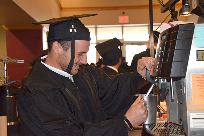 On his last day as an undergraduate at Campbellsville University, Johan Fuzellier uses his barista skills at Starbucks to make a coffee while waiting for the senior walk. (Campbellsville University Photo by Tomomi Sato) 