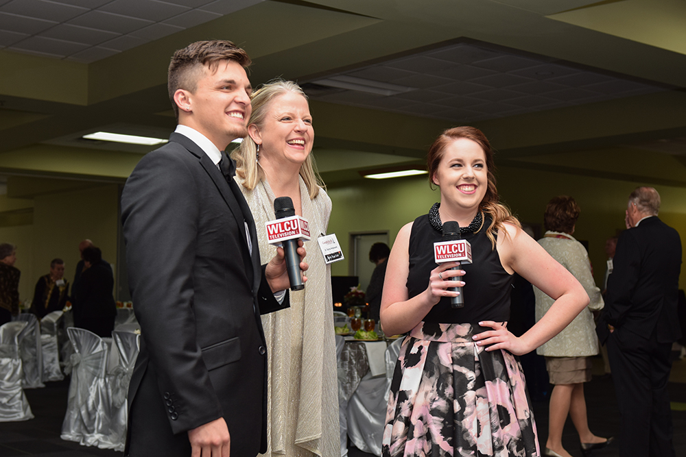 Christian Naylor, left, and Jesslyn McCandless, third from left, interview Dr. Donna Hedgepath, vice president for academic affairs, at the 9th Annual Derby Rose Gala at Campbellsville University. (Campbellsville University Photo by Joshua Williams)