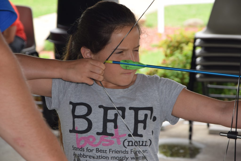 During the Archery class, offered by the Kids College on Campbellsville University’s campus, Keira Gadberry of Liberty, Ky. focuses on her target before she releases.  (Campbellsville University Photo by Ariel Emberton)