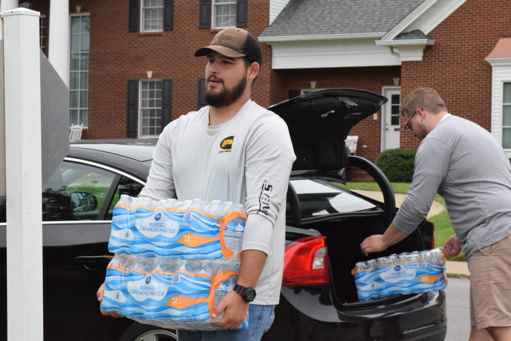 Adam Carmen and Lucas Humphrey carry cases of water to Stapp Lawn for hurricane relief donation. (CU photo by Andrea Burnside)