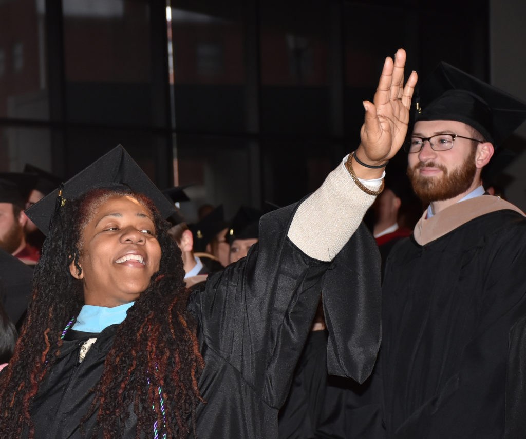 Gwendolyn Denise Atkinson-Sample of Louisville, Ky., waves at her family during the commencement at Campbellsville University. (Campbellsville University Photo by Ariel Emberton)