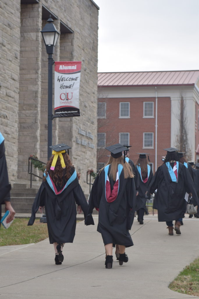 These graduates take their last walk from Davenport Student Commons to Ransdell Chapel before their commencement ceremony. (Campbellsville University Photo by Andrea Burnside)